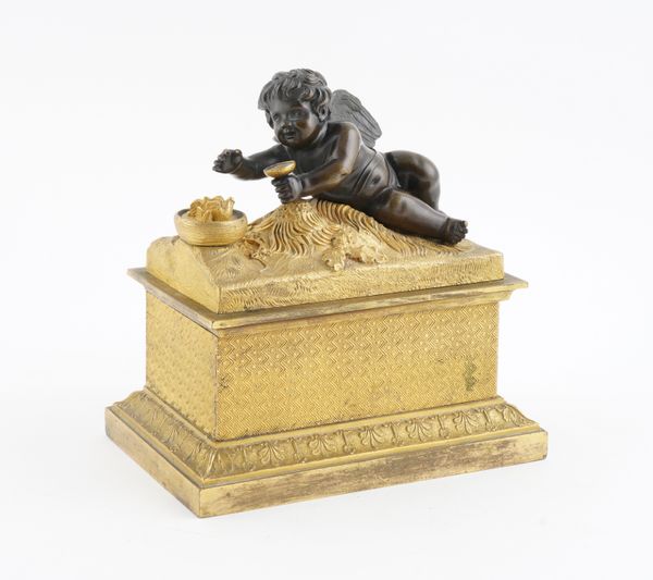 A RESTAURATION ORMOLU INKSTAND OR ENCRIER WITH BRONZE WINGED PUTTO MOUNTED COVER