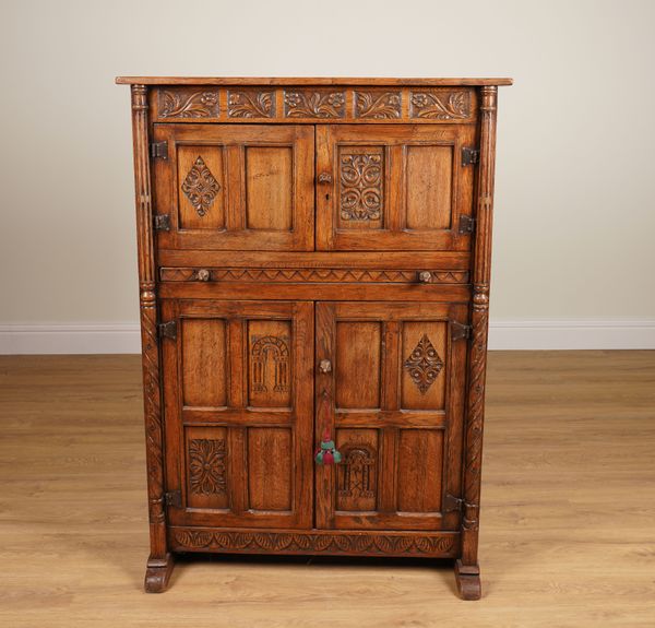 A 17TH CENTURY STYLE CARVED OAK SIDE CABINET ON SLEIGH FEET