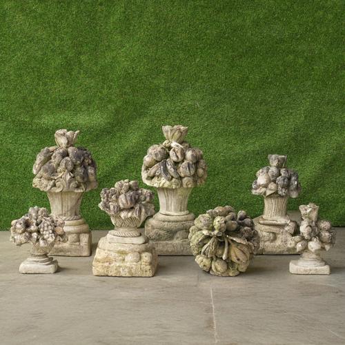 A SET OF FOUR VICENZA STONE FINIALS MOULDED AS FLOWERS AND FRUIT (11)