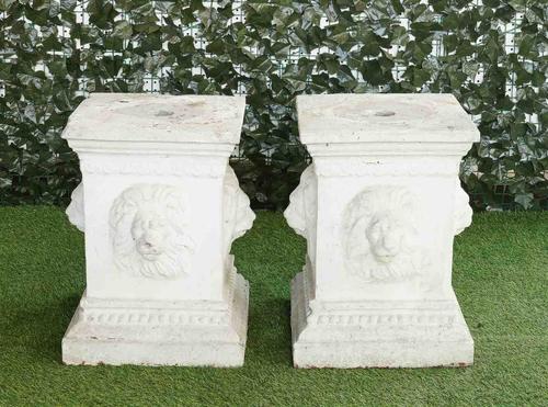 A PAIR OF WHITE PAINTED TERRACOTTA PLINTHS WITH LION MASK DECORATION (2)