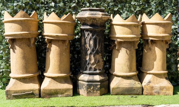 A SET OF FOUR TERRACOTTA CHIMNEY POTS WITH POINTED CASTELLATED TOPS (5)