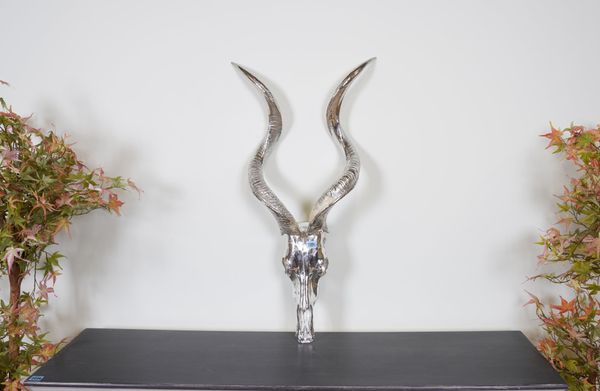 A SILVER PAINTED FAUX ANIMAL SKULL WITH SPIRAL HORNS