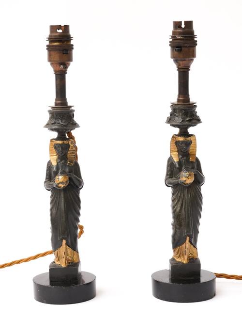 A PAIR OF FRENCH BLACK PATINATED AND GILT HEIGHTENED SPELTER PHAROAH CANDLESTICKS (2)