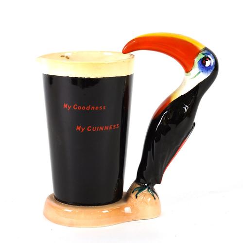 A CARLTON WARE GUINNESS JUG MODELLED AS A PINT OF GUINNESS WITH A TOUCAN HANDLE