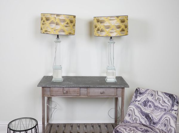 LIGHTING, A PAIR OF HEAVY CUT GLASS TABLE LAMPS OF COLUMN FORM, WITH GOLD AND SILVER SILK SHADES