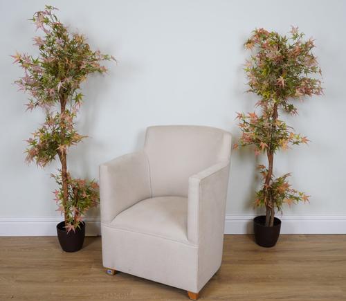 A CREAM UPHOLSTERED BARREL ARMCHAIR