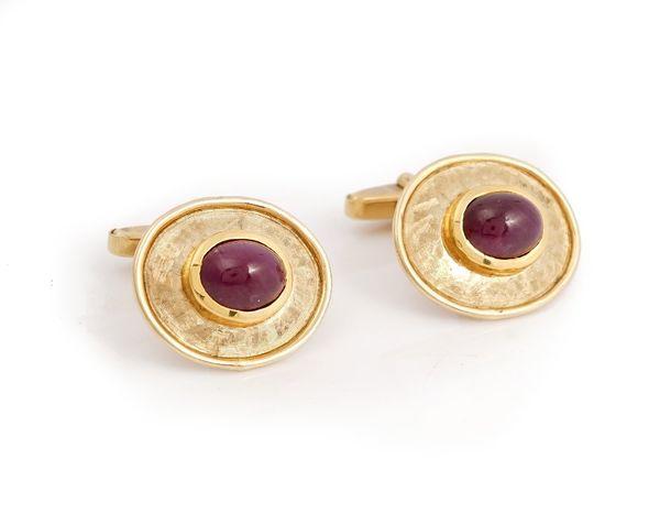 A pair of 9ct gold and cabochon ruby dress cufflinks, each mounted with an oval cabochon ruby to the front, on a textured oval ground, the backs with