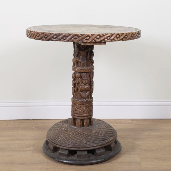 A TRIBAL CARVED HARDWOOD AND HARDSTONE INLAID CIRCULAR OCCASIONAL TABLE