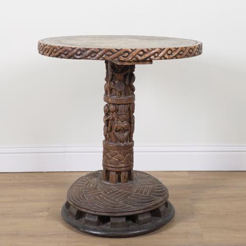 A TRIBAL CARVED HARDWOOD AND HARDSTONE INLAID CIRCULAR OCCASIONAL TABLE
