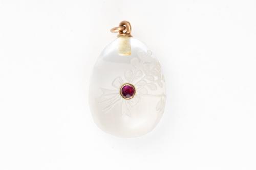 AN EARLY 20TH CENTURY ROCK CRYSTAL AND RUBY EGG CHARM