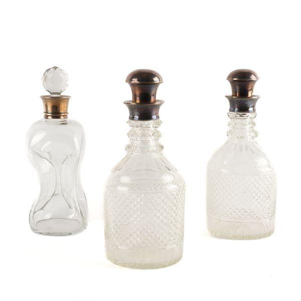 A PAIR OF SILVER MOUNTED FACETED GLASS DECANTERS AND A SILVER MOUNTED DIMPLE GLASS DECANTER (3)