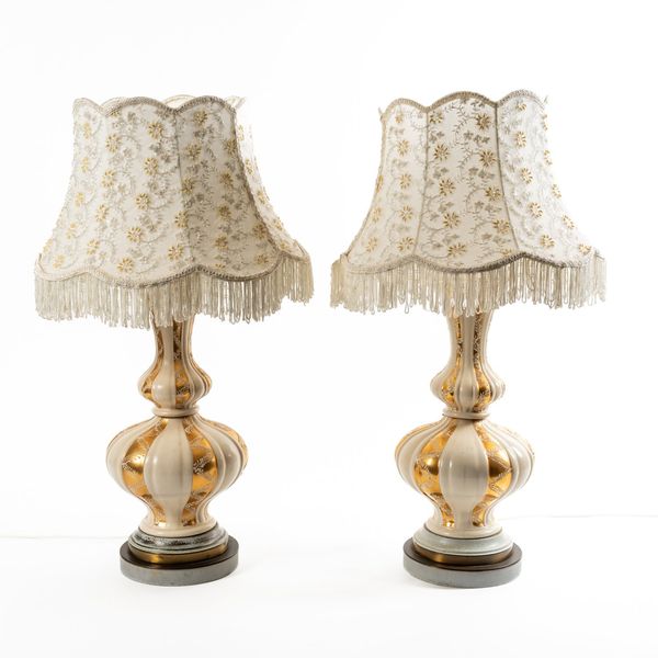 A PAIR OF PARCEL GILT AND CREAM CERAMIC BALUSTER TABLE LAMPS (2)