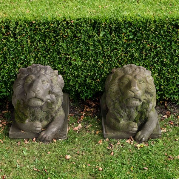 A PAIR OF RECONSTITUTED STONE FIGURES OF RECUMBENT LIONS (2)