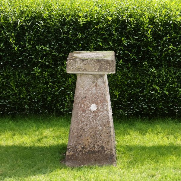 A CARVED STONE STADDLE STONE