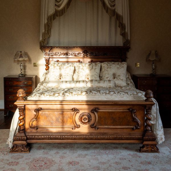 A CONTINENTAL CARVED WALNUT DOUBLE BED