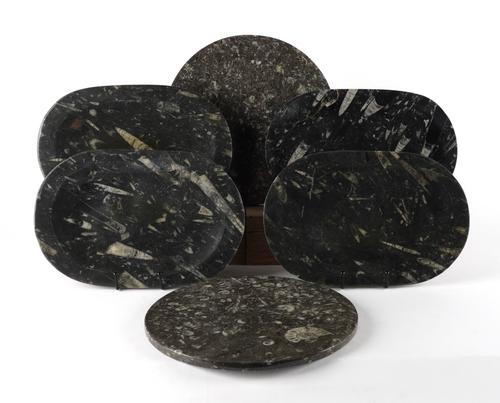 A SET OF FOUR FOSSIL OVAL PLATTERS OR SERVING DISHES AND TWO CHEESE BOARDS WITH ORTHOCERAS AND GONIATITE INCLUSIONS (6)