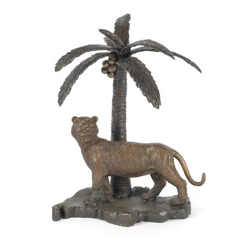 A PATINATED BRONZE MODEL OF A TIGER UNDER A PALM TREE