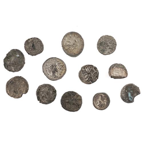 A GROUP OF TWELVE MOSTLY ROMAN SILVER AND DEBASED SILVER COINS