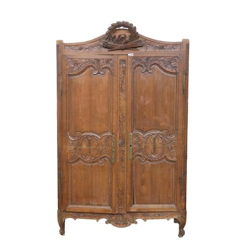 AN EARLY 19TH CENTURY FRENCH CARVED STAINED PINE TWO DOOR ARMOIRE