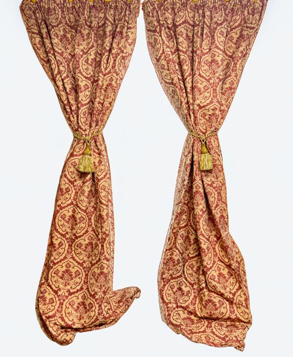 A PAIR OF RED AND GOLD LINED AND INTERLINED CURTAINS