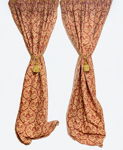 A PAIR OF RED AND GOLD LINED AND INTERLINED CURTAINS