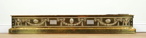 A NEO-CLASSICAL REVIVAL BRASS FENDER AND TRIVET (2)