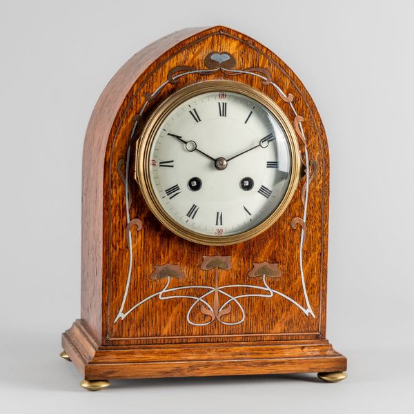 AN EDWARDIAN OAK AND METAL-INLAID LANCET CLOCK