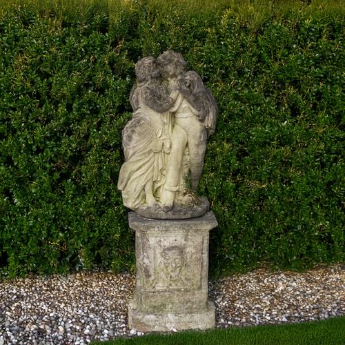 A RECONSTITUTED STONE FIGURE MODELLED AS AN EMBRACING MAN AND WOMAN