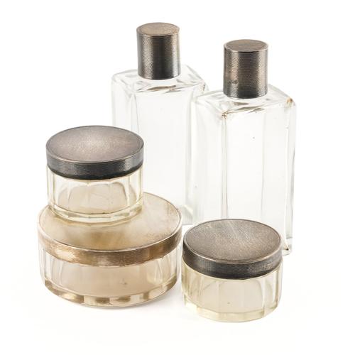 A GROUP OF FIVE SILVER LIDDED GLASS TOILET BOTTLES AND JARS (5)