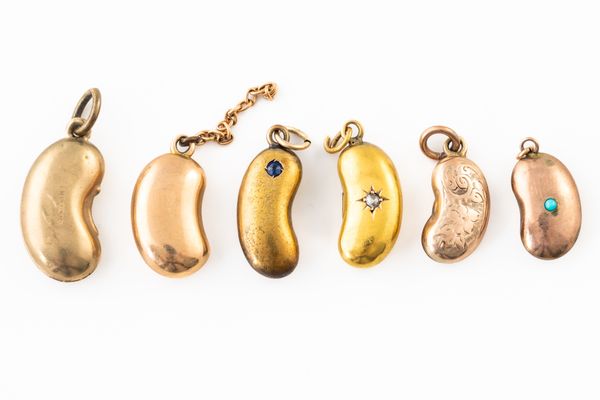 A GROUP OF SIX GOLD BEAN CHARMS (6)