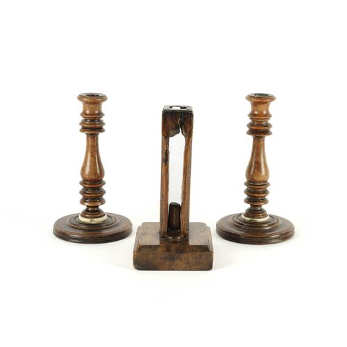 A PAIR OF TREEN CANDLESTICKS AND AN UNUSUAL OAK SQUARE SECTION EJECTOR CANDLESTICK (3)
