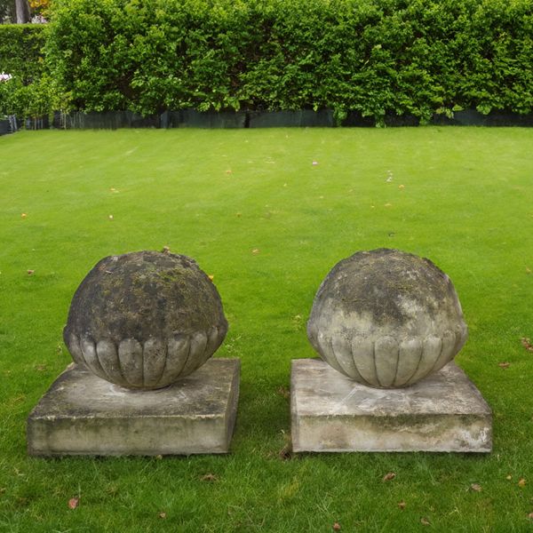 A PAIR OF RECONSTITUTED STONE SEMI GADROONED GATE PIER SPHERES