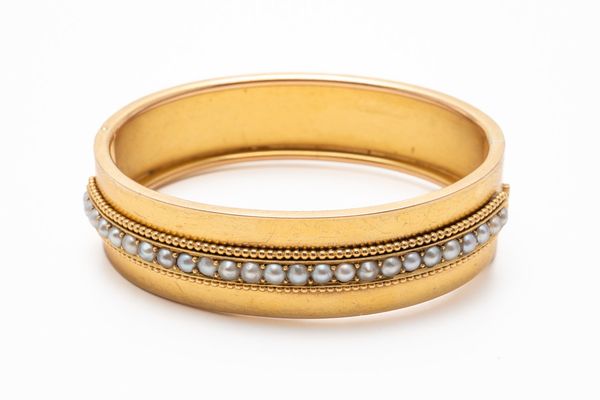 A VICTORIAN GOLD AND HALF PEARL OVAL HINGE BANGLE