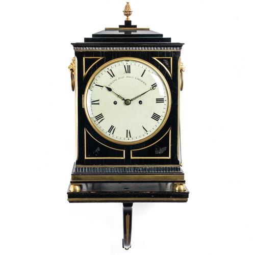 A REGENCY BRASS-MOUNTED EBONISED STRIKING BRACKET CLOCK AND BRACKET