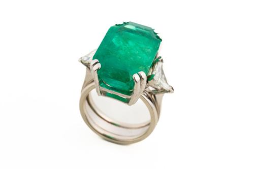 AN EMERALD AND DIAMOND SET THREE STONE RING