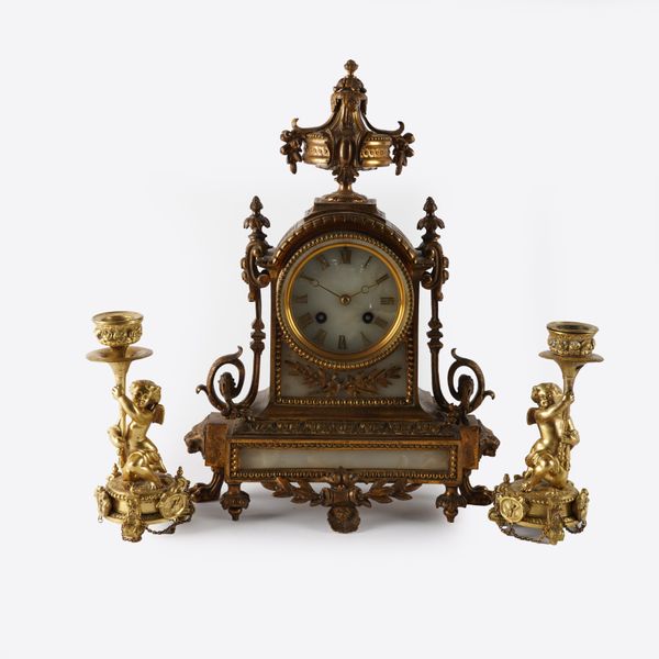 A FRENCH LOUIS XVI STYLE GILT-METAL AND WHITE ONYX MOUNTED MANTEL CLOCK AND A PAIR OF GILT-BRASS CANDELSTICKS (3)