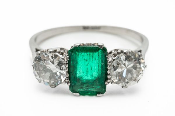 AN EMERALD AND DIAMOND THREE STONE RING