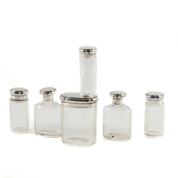 SEVEN SILVER LIDDED GLASS TOILET BOTTLES AND JARS (7)