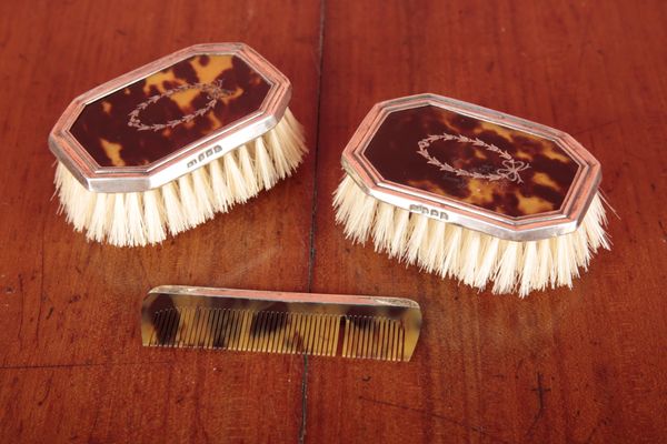 AN EDWARDIAN PAIR OF TORTOISEHELL AND SILVER FRAMED BRUSHES