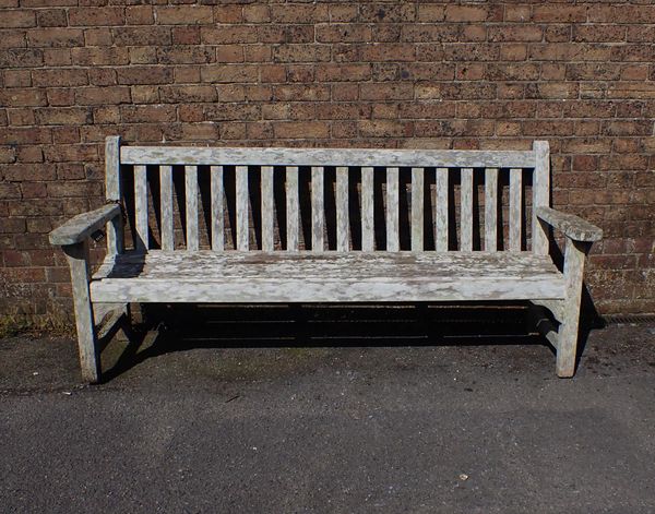 A WEATHERED TEAK GARDEN BENCH