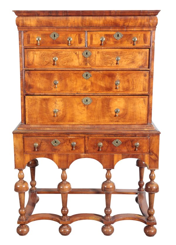 A WILLIAM AND MARY FIGURED WALNUT CHEST ON STAND