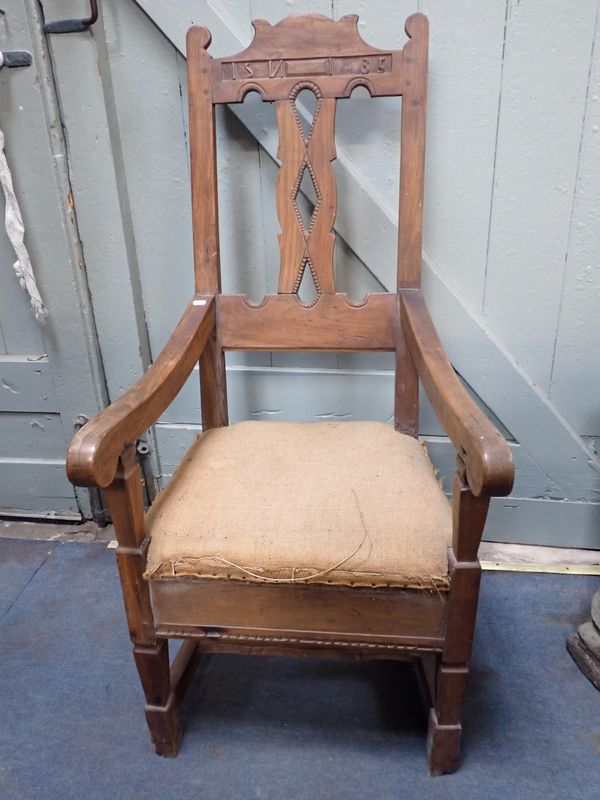 AN ARMCHAIR WITH PRIMITIVE CARVING