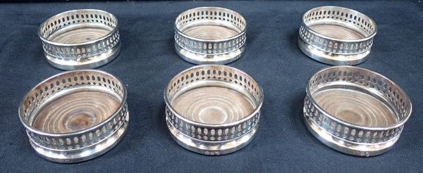 A SET OF SIX SMALL SILVER PLATED WINE COASTERS