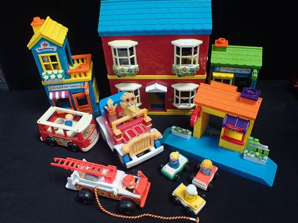 A TOY VILLAGE WITH FISHER-PRICE VEHICLES AND PEOPLE