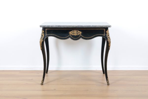 AN EBONISED AND GILT METAL SIDE TABLE IN ROCOCO STYLE