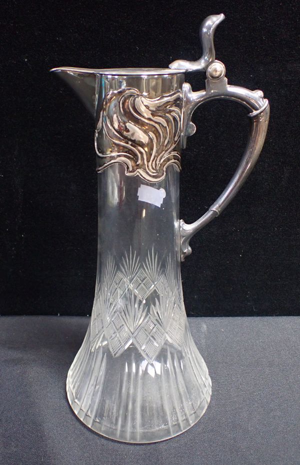 AN EDWARDIAN SILVER PLATED AND CUT GLASS CLARET JUG