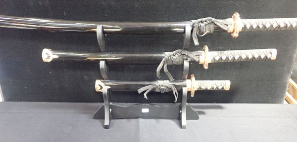 A SET OF THREE MODERN JAPANESE SWORDS ON STAND