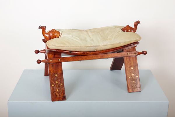 A CARVED WOOD CAMEL SADDLE FOOT STOOL
