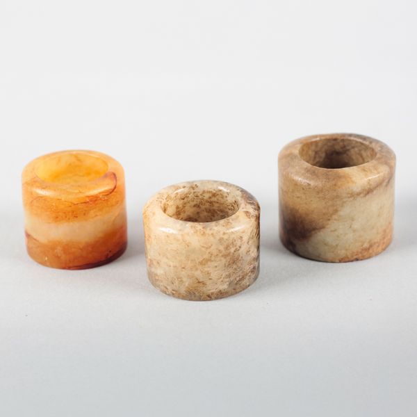 A GROUP OF THREE CHINESE JADE ARCHER'S RINGS