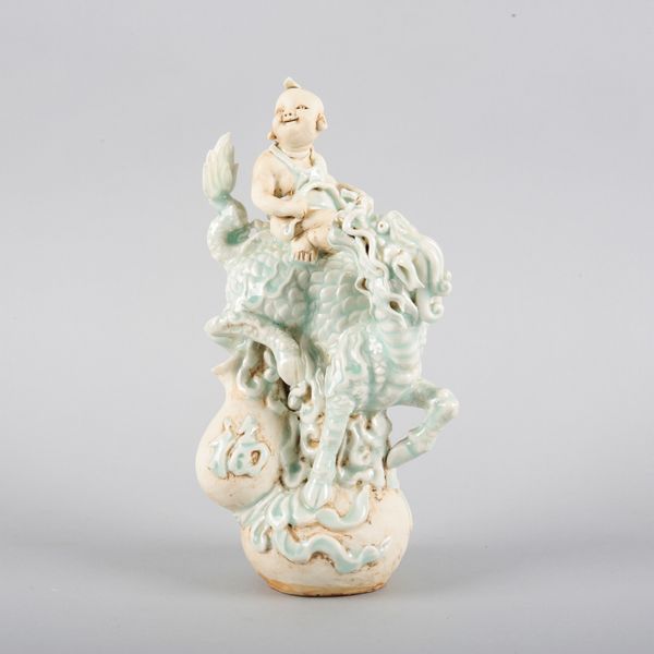 A CHINESE PORCELAIN QINGBAI GROUP OF A BOY RIDING A QILIN